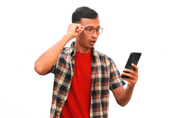 An Asian man shows a thinking expression while holding a cellphone.