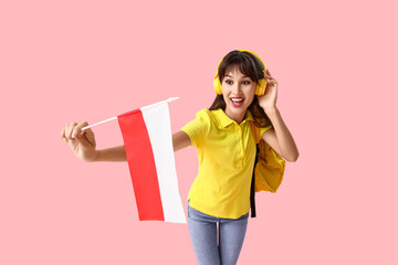 Female student in headphones with flag of Poland on pink background