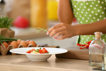 Young housewife cooking tasty pasta in kitchen, closeup