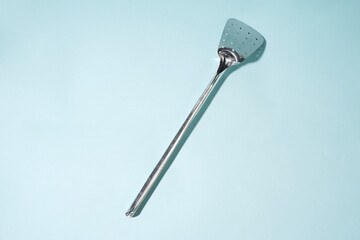 Stainless Steel Perforated Spatula on a Light Blue Background