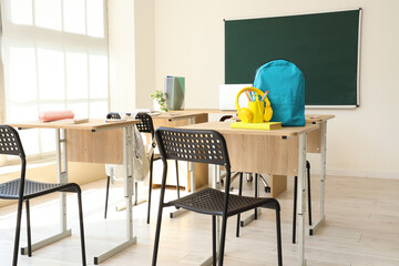 Interior of classroom with desks and backpacks