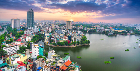 Aerial view of road crossing the island Westlake, Hanoi, Vietnam with green tree lined street, temple located between small oasis. A beautiful sunset in capital of Vietnam