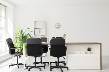 Interior of conference hall with desk, shelf unit and palm plant