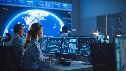 People in a modern control room monitoring data on computers - Powered by Adobe