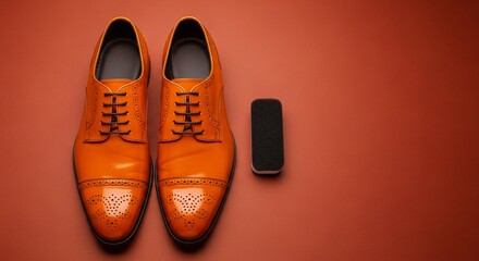 Shiny orange leather oxford shoes with polishing sponge