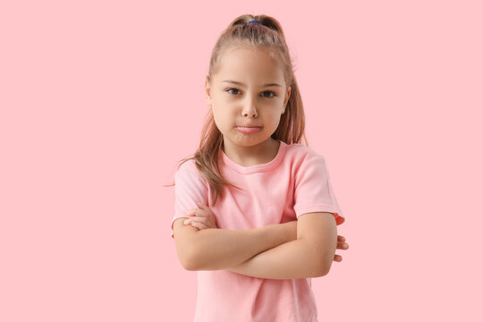 Sad little girl on pink background