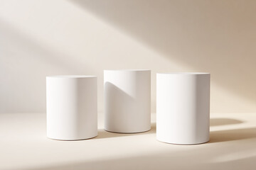 3 white, minimal cylindrical pedestal podiums on a light background,
