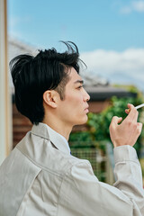 タバコ休憩をする作業服姿の男性