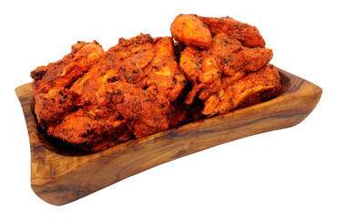 Tandoori marinated oven baked chicken meat in a wooden serving dish isolated on a white background