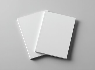 Two blank white books resting on a light gray surface