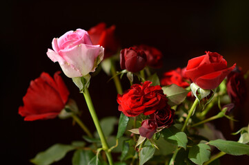 bouquet of colorful roses in the clay vintage vase at the table