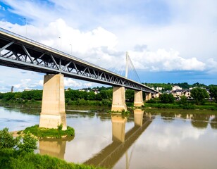 Obraz premium Modern bridge spans river, reflecting in calm water, under partly cloudy sky