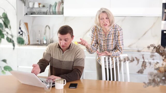 Family quarrel, mother blaming son, son is busy with laptop. Family quarrel of mother and son. High quality 4k footage