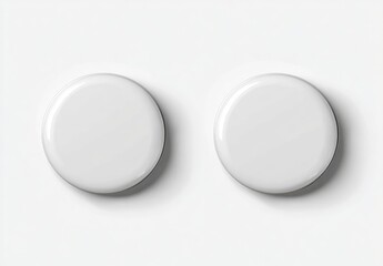 Two blank, white, round buttons, slightly raised, on a white background