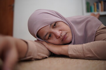Sad lonely Asian muslim woman pondering blankly, contemplating in frustration, depressed person 
