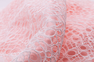 White lace with intricate openwork design on soft pink background, radiating romantic elegance and...