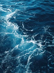 Deep blue ocean surface with foamy waves