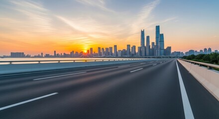 Cityscape skyline at sunset with empty road leading to urban downtown, showcasing modern architecture, business district, and transportation infrastructure