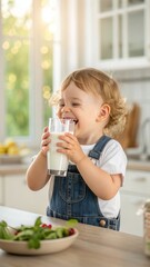 Happy toddler with curly hair enjoying a glass of milk in bright kitchen