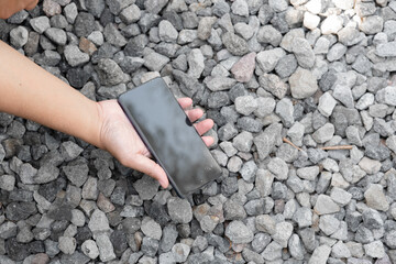 A person is holding a cell phone in their hand. The phone is black and has a case