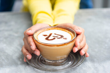 Close-up image of a cup of coffee held in hands.Hand-roasted coffee, authentic coffee. A dose of...