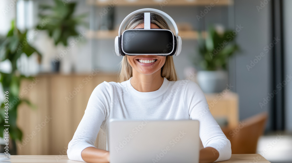 Poster virtual reality user smiling while wearing headset and using laptop in modern workspace