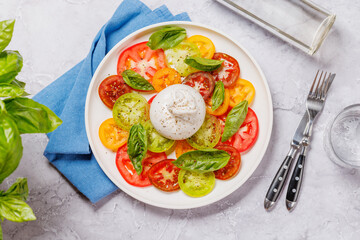 Fresh burrata served on slices of colorful tomatoes