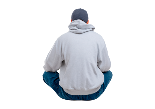 Male in gray hoodie and cap sitting cross-legged from back view on transparent background, PNG