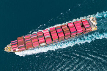 Giant container ship heavy ship goes on water with a lot of cargo in the sea strait when entering the port, side aerial view directly from air from above