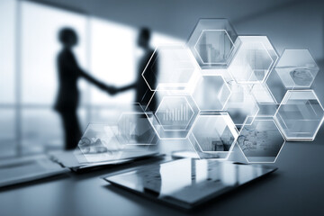 Two business professionals shaking hands with abstract hexagonal interface displaying graphs and cityscapes.