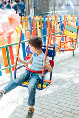 boy riding on an amusement swing