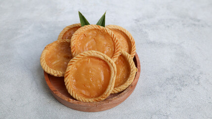 Pie Susu or custard tarts is popular snack from Bali, Indonesia, on grey background