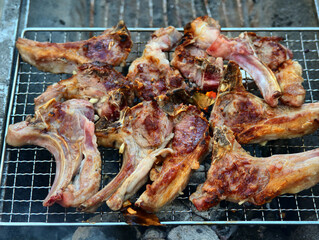 Grilled lamb chops cooking on a barbecue grid over hot coals for a summer meal © IMRAN_IM33