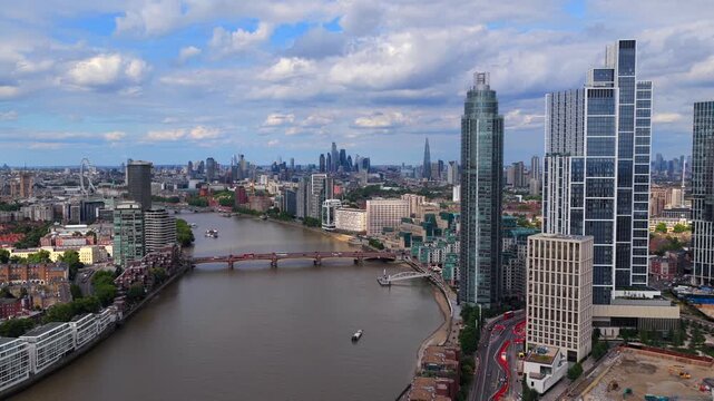 Aerial video of Vauxhall riverfront in South London where the River Thames curves past a cluster of bold modern skyscrapers	
