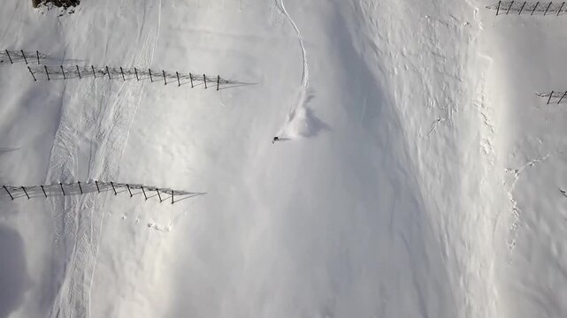 Skier descending a steep, pristine snow-covered mountain