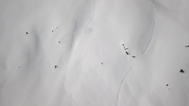 Skier descending a steep, pristine snow-covered mountain