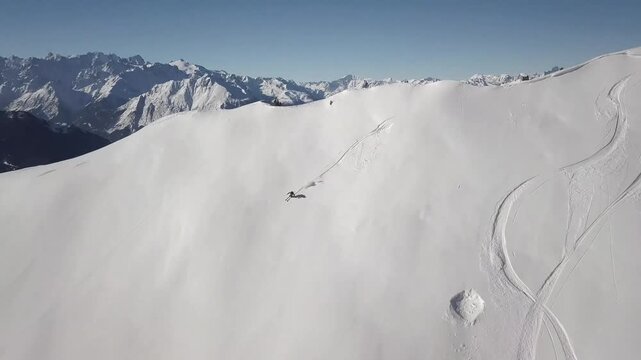 Skier descending a steep, pristine snow-covered mountain