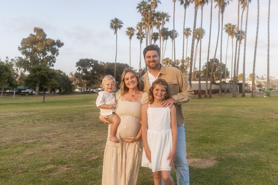 Happy Young Family Posing Outdoors at Sunset