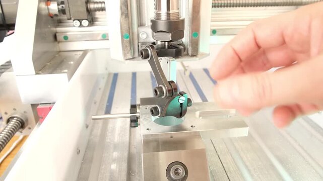 Fingers check the alignment and motion of a machine part