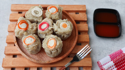steamed dumpling dimsum. homemade dimsum with various topping served on wooden plate
