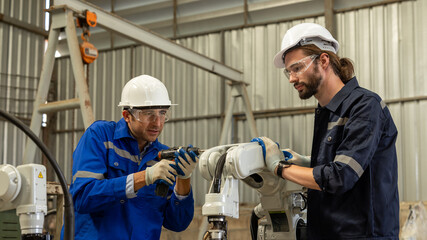 Electrical engineer testing artificial intelligence robot arm at high technology research...