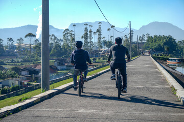 Rear View Of Cyclists Pedaling Through A Rural Area