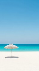 White umbrella providing shade on a beautiful tropical beach with turquoise water and clear blue sky perfect for summer vacation getaway