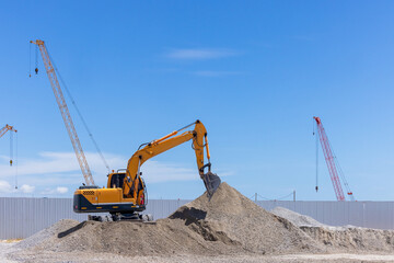 Construction site with excavator construction crawler crane and multi storey unfinished buildings, Many high rise cranes and industrial construction equipment, Contruction site excavator
