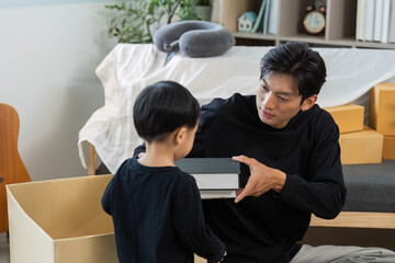 Father and child bonding during home organization and unpacking