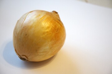 Close-up of a whole brown onion placed on a plain white background with copy space, perfect for...