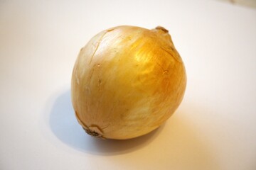 Close-up of a whole brown onion placed on a plain white background with copy space, perfect for...