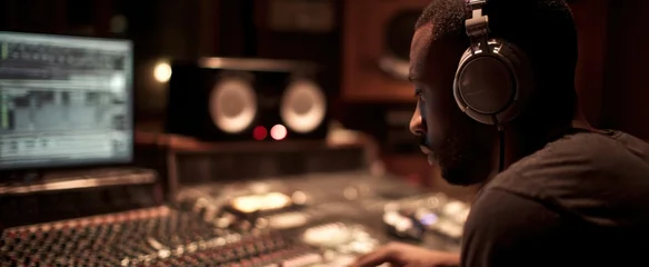 The focused music producer in a modern recording studio environment. © Marta B