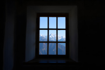 Fototapeta premium Snow capped mountain range seen through a window peak blue