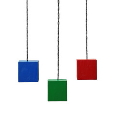 Hanging primary color wooden cubes with chains against a black background display
